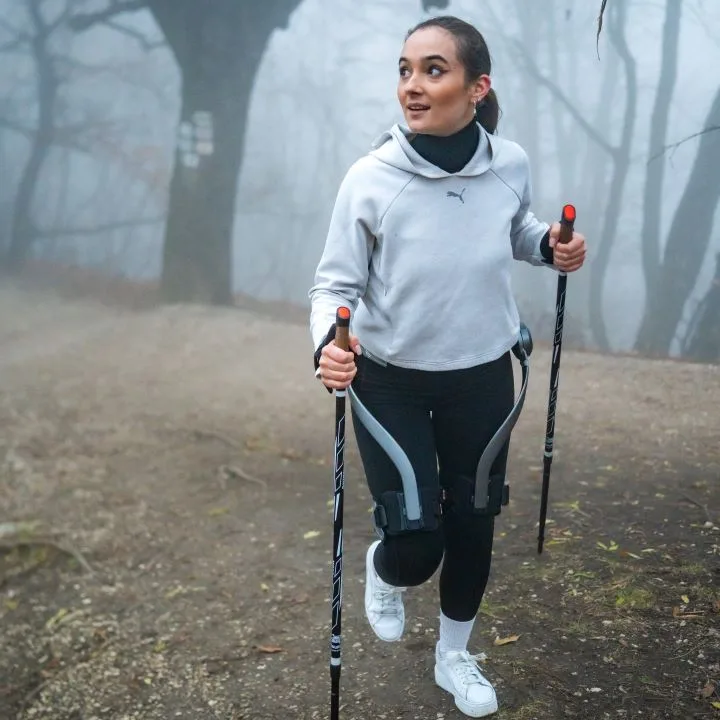 A young girl using Hypershell exoskeleton during hiking in autumn near Budapest