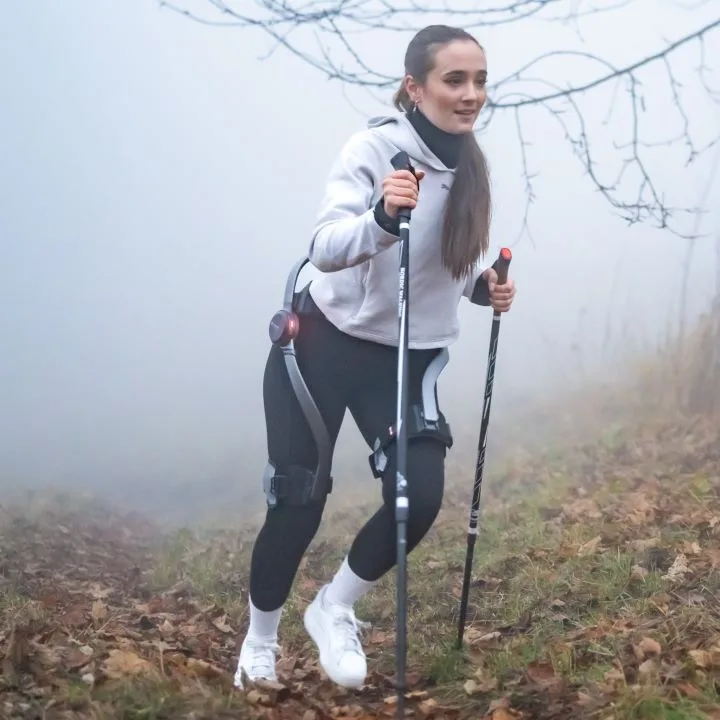 A young girl using Hypershell exoskeleton during a hike in the woods