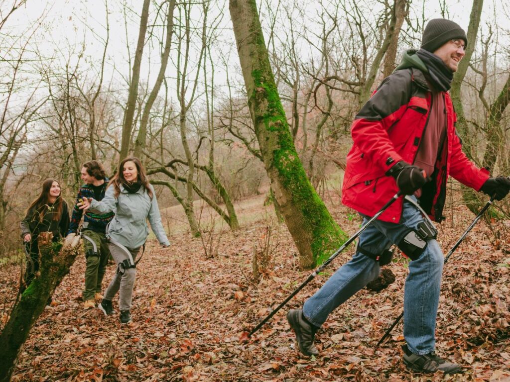 Three people wearing Hypershell hiking in the woods during an exoskeleton powered tour in Budapest, Hungary