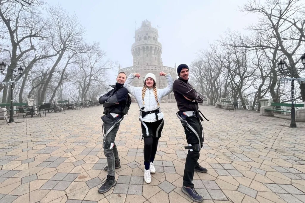Three people wearing Hypershell exoskeletons posing in front of the iconic Elizabeth lookout in Budapest, Hungary